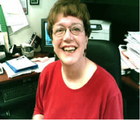 picture of Gail Burns Smith sitting in a red blouse