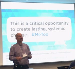 David Lee, a baolding white man stading in front of screen saying "This is a critical opportuhnity to lasting systematic change... #MeToo"