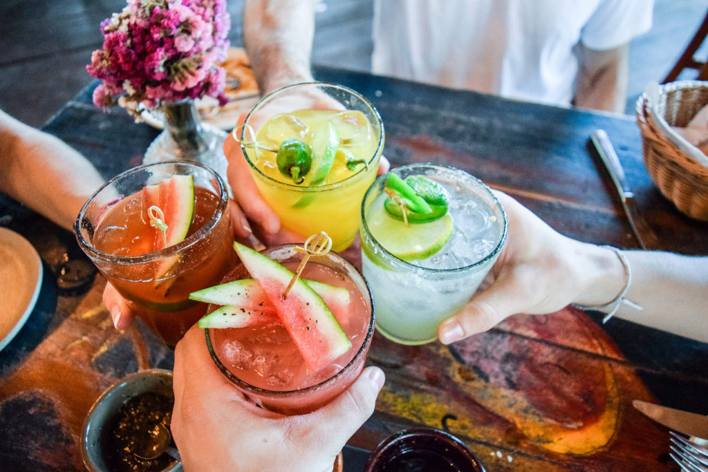 Friends toasting, saying cheers holding tropical blended fruit margaritas. Watermelon and passionfruit drinks.; Shutterstock ID 780298633; AP/Pedido de Compra (opcional): -